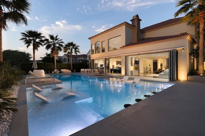 Luxury villa with a modern poolside featuring large glass doors and windows by Oryx Doors and Windows Dubai.