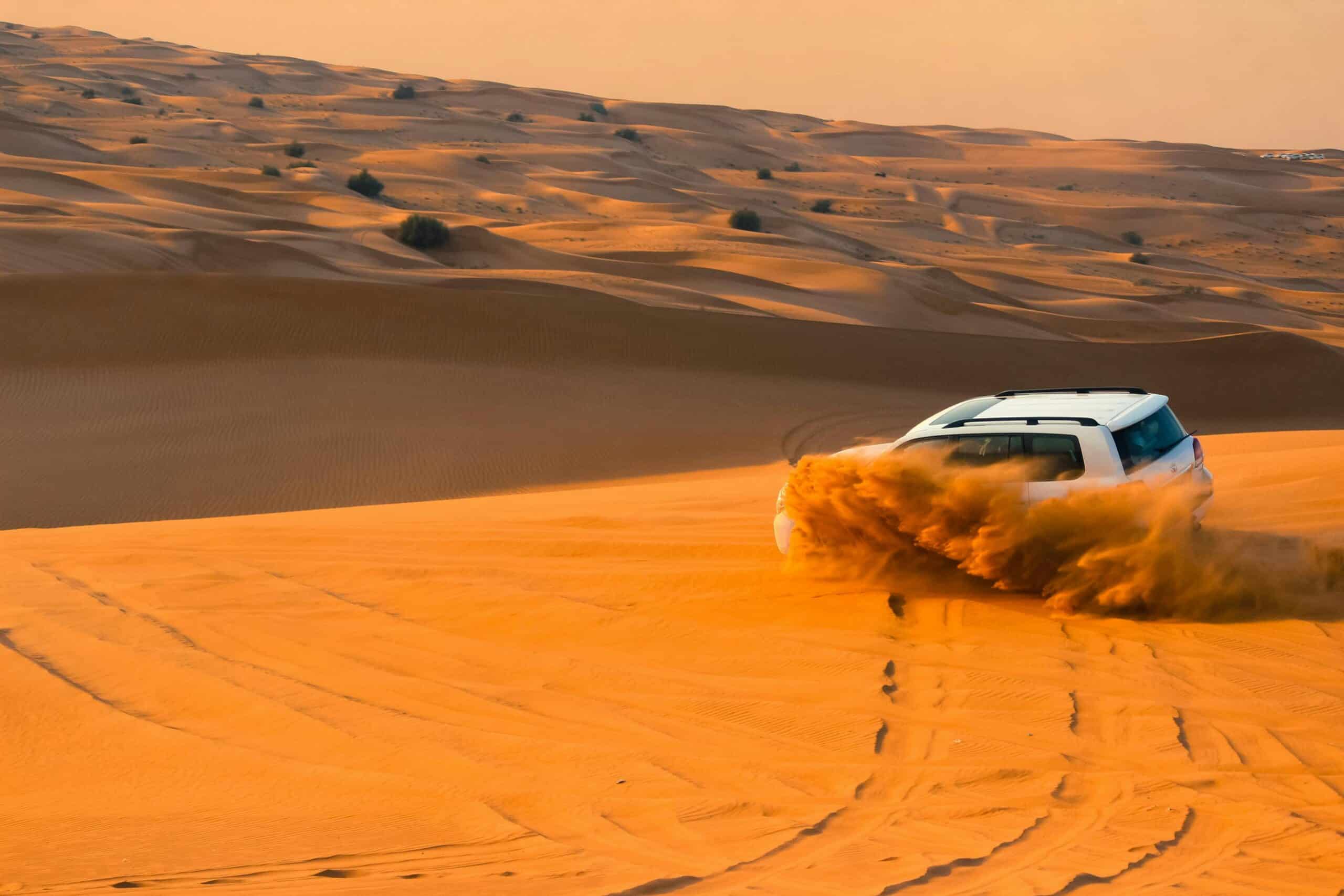 A 4x4 vehicle traversing the sand dunes in the UAE desert