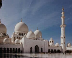 Sheikh Zayed Grand Mosque in Abu Dhabi, featured in the UAEThrive Daily News Roundup, showcasing stunning domes and elegant minarets under a clear blue sky.
