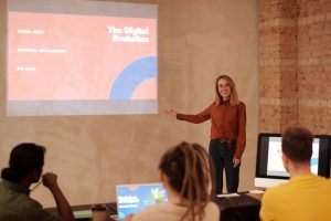 UAEThrive Daily News Roundup: Woman presenting on digital evolution concepts like AI and big data in a seminar.
