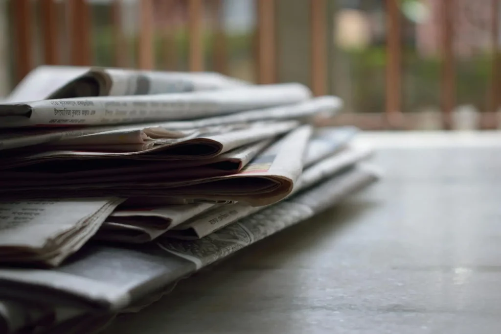 Stack of newspapers lying on a table, illustrating daily news updates in the UAE.